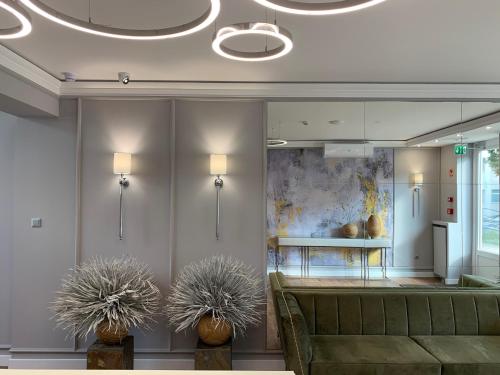 a lobby with a couch and two potted plants at Boutique Hotel Center in Kecskemét