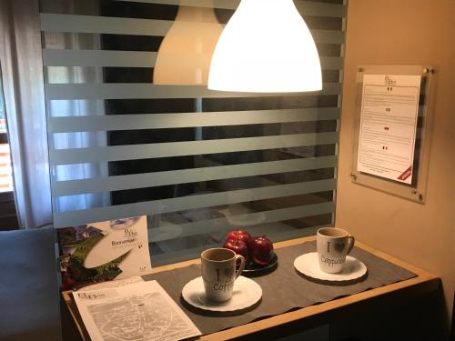 a table with two coffee cups and fruit on it at Casa Bona in Alba