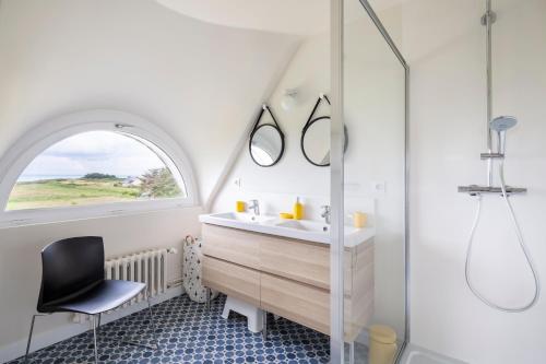 baño con lavabo, ventana y silla en Le Sémaphore - Maison avec vue face à la mer, en Cancale