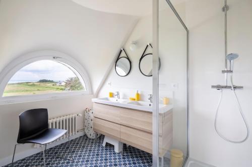 a bathroom with a sink and a window and a chair at Le Semaphore by Cocoonr in Cancale