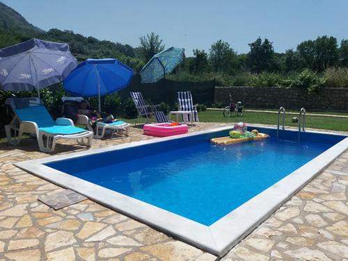 una piscina con un parque acuático con sombrillas en Zelena Maslina, en Bar