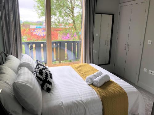a bedroom with a bed with pillows and a large window at Ecohome on the canal in a historic site near city in Coventry