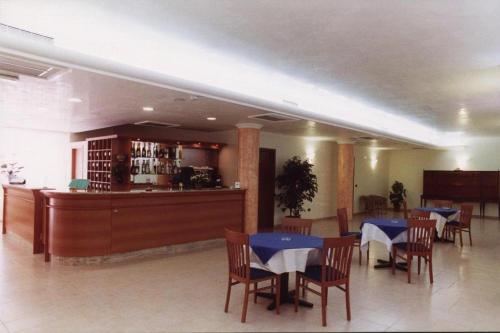 a restaurant with tables and chairs and a bar at Hotel Sirios in San Giovanni Rotondo