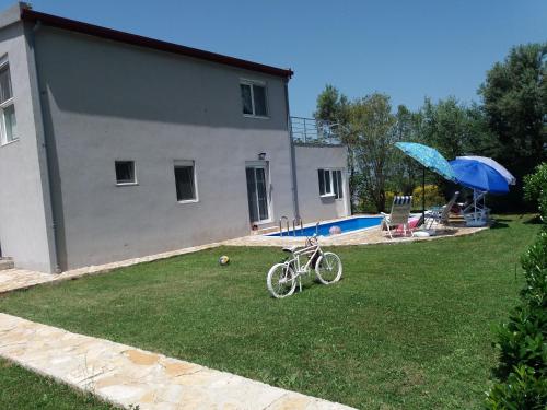 a bike parked in a yard next to a house at Zelena Maslina in Bar