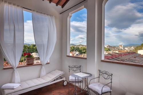 a balcony with two windows and a bench and chairs at Dimora Bandinelli in Florence