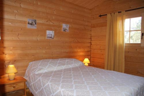 une chambre avec un lit dans une cabane en rondins dans l'établissement chalet climatisé Porticcio Corse, à Fontanaccio