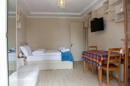 a small room with a bed and a table and chairs at Pearl apartment in Kutaisi in Kutaisi