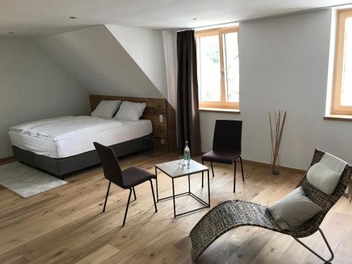 a bedroom with a bed and chairs and a table at Kallido in Hermeskeil