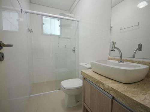 y baño con lavabo, ducha y aseo. en 1041 - Apartamento na Praia de Bombinhas para locação - Residencial Egídio Pinheiro 304 B, en Bombinhas