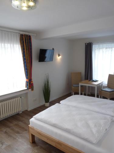 a bedroom with a bed and a tv on the wall at Pension Haus Baltic in Dahme
