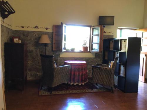 ein Wohnzimmer mit einem Tisch, Stühlen und einem Fenster in der Unterkunft Camangu-Estudio in Ribadesella