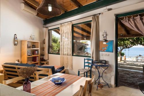 a living room with a table and chairs and a view of the ocean at apartment over the sea Private place to swim in Ravdhoúkha