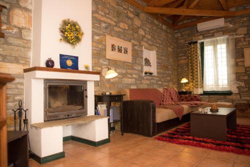 a living room with a couch and a fireplace at Pelion Goddess Villas in Agios Georgios Nilias