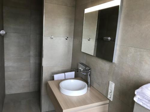 a bathroom with a white sink and a mirror at Kallido in Hermeskeil