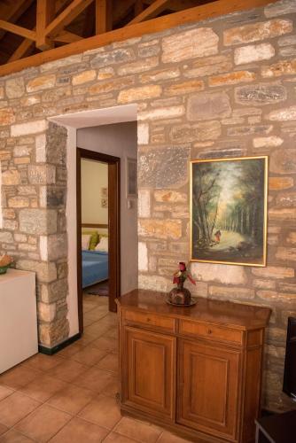 a room with a stone wall with a painting on the wall at Pelion Goddess Villas in Agios Georgios Nilias