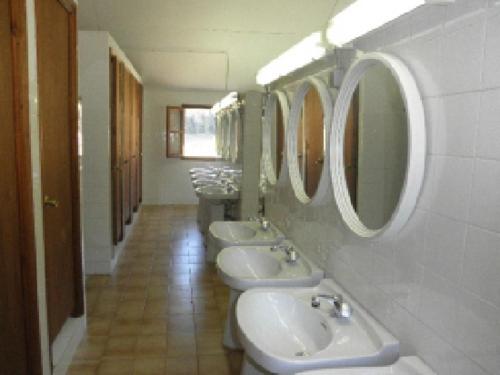 uma casa de banho com três lavatórios e uma fila de espelhos em Borda Cortals de Sispony em La Massana