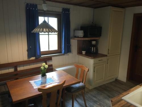 una cucina con tavolo in legno, sedie e finestra di CS-Ranchhaus a Hörselberg-Hainich