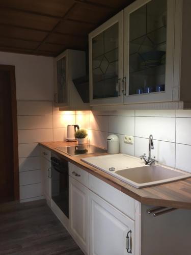a kitchen with white cabinets and a sink at CS-Ranchhaus in Hörselberg-Hainich