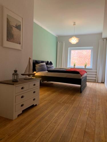 um quarto com uma cama, uma cómoda e uma janela em Lubblerhof em Fehmarn