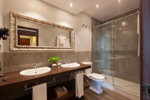 a bathroom with two sinks and a shower at Hotel Diana in Tossa de Mar