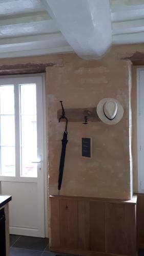 a room with a wall with a gun and a door at Maison Camille in Port-en-Bessin-Huppain