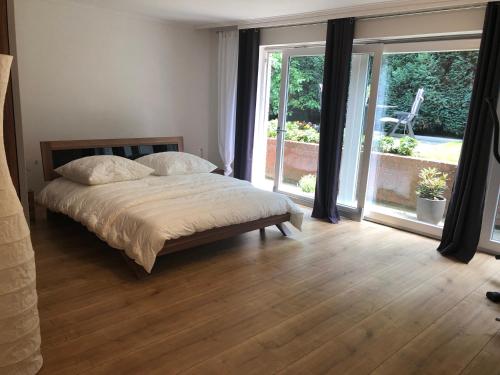 - une chambre avec un lit et une grande fenêtre dans l'établissement Villa Drita, à Alsdorf