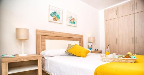 a bedroom with a bed with a yellow pillow at Ona Suites Salou in Salou