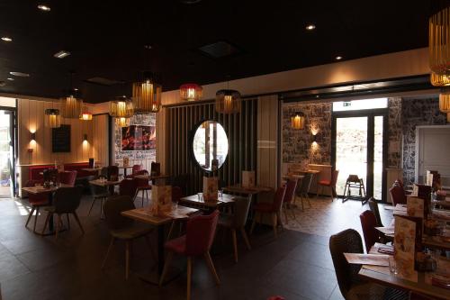 a dining room with tables and chairs and chandeliers at ibis Marseille Provence Aéroport in Marignane