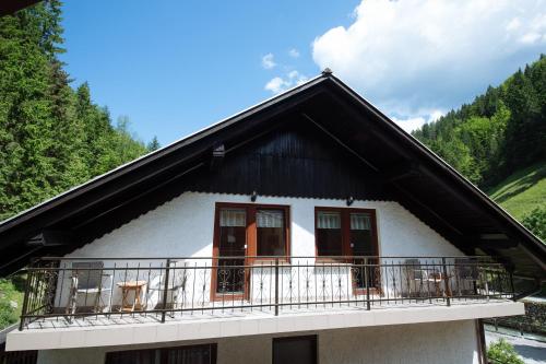 a small white house with a balcony at Turistična kmetija Čerček in Solčava