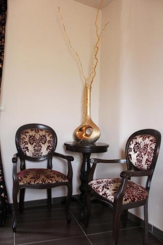 two chairs sitting next to a table with a vase at Guesthouse Vavitsas in Kalabaka