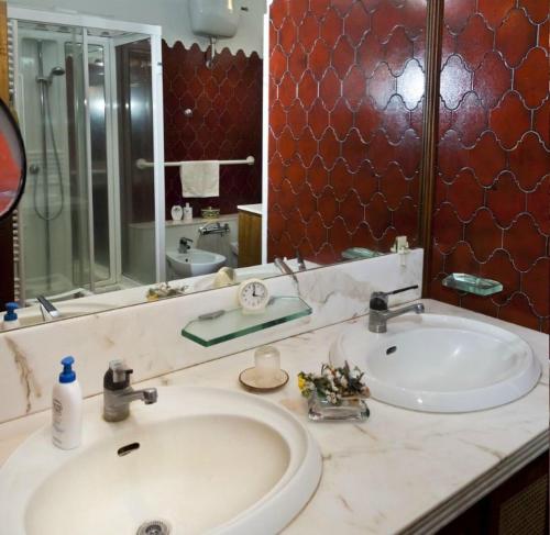 een badkamer met een wastafel en een grote spiegel bij B&B Ippolito in Orvieto