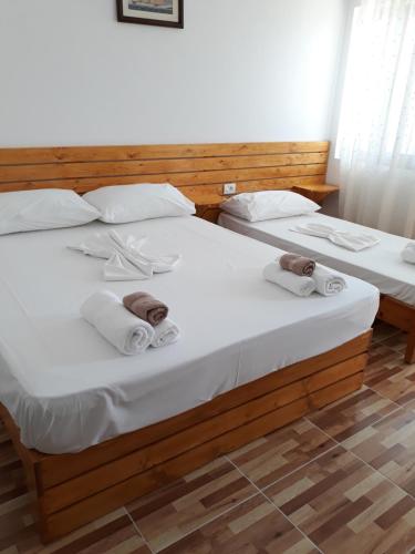 two beds in a room with towels on them at Beleris Rooms in Himare