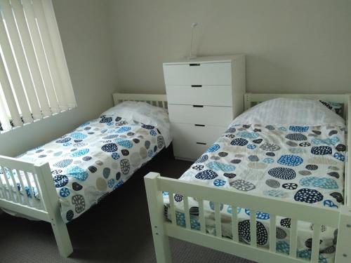 a bedroom with two beds and a dresser at Near Train Station in Perth