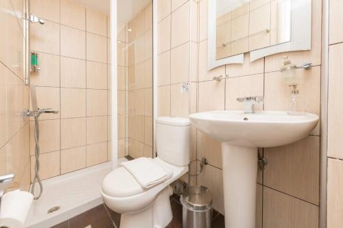 a bathroom with a toilet and a sink and a shower at Promenade Sea View Apartment in Limenas
