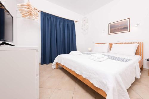 a bedroom with a large bed and a blue curtain at Promenade Sea View Apartment in Limenas