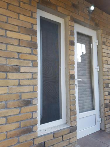 two windows on a brick wall next to a door at Apartments like hotel in Chernivtsi