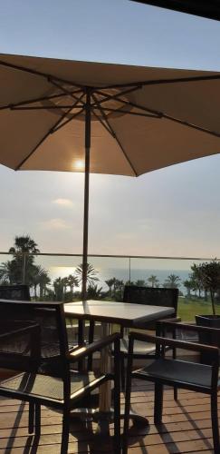 a table and chairs with an umbrella on a patio at Terrazza Suites in Paphos City