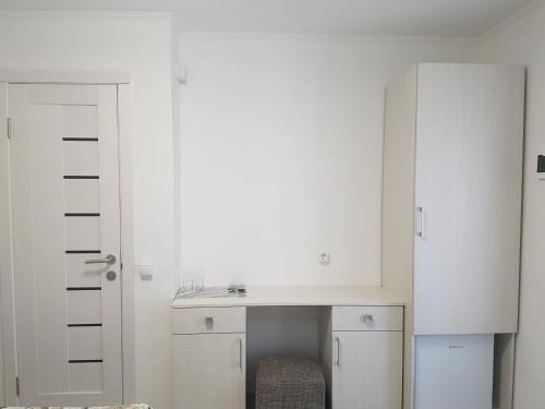 a white room with a desk and a cabinet at Apartments like hotel in Chernivtsi