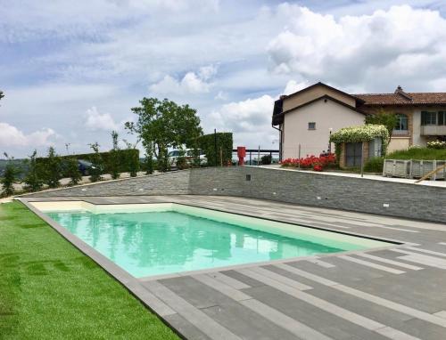 a swimming pool in a yard next to a house at Locanda Del Pilone in Alba