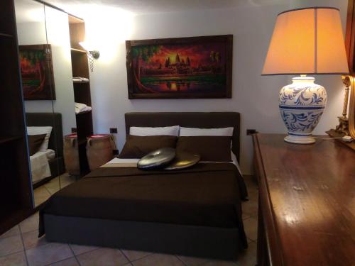 a bedroom with a bed with a lamp on a table at Suite Bobo relax nel chianti classico gallo nero in Strada