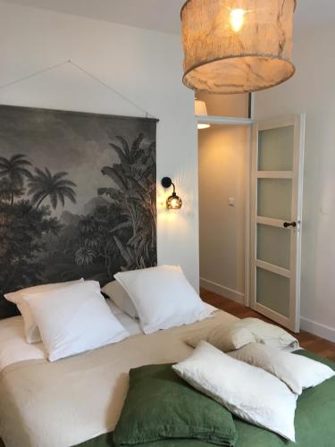 une chambre avec un grand lit avec des oreillers blancs dans l'établissement Hôtel de Ville 1, à La Rochelle