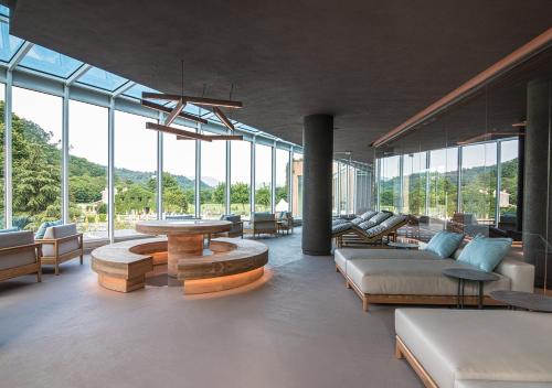 a living room with a lot of windows at Terme Preistoriche Resort & Spa in Montegrotto Terme