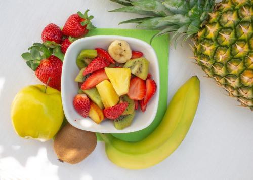 a bowl of fruit on a plate next to a pineapple at Hotel Europa in Garda