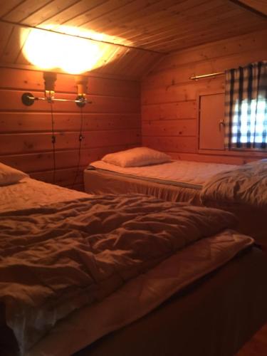 a room with two beds in a wooden cabin at Metsorinne in Kotila