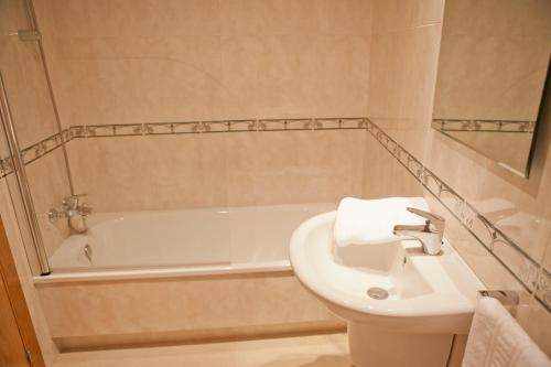 a bathroom with a sink and a bath tub at Hotel Brisa del Mar in O Grove
