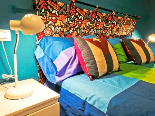 a bedroom with a bed with colorful pillows on it at MODERN & BRIGHT flat - 2 MIN from the SEA in Savona