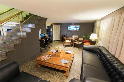 uma sala de estar com um sofá e uma mesa em Hotel Plaza Apolo em São Paulo