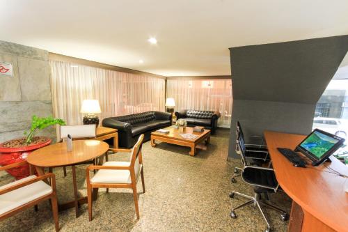 a living room with a couch and a table at Hotel Plaza Apolo in Sao Paulo