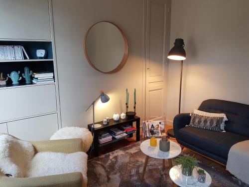 a living room with a couch and a table at L'Echiquier de Normandie confort cosy et vue premium in Rouen
