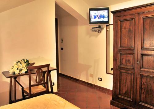 a bedroom with a bed and a table and a tv at Hotel Bucaneve in Pescasseroli